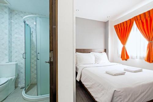 a bedroom with a bed and a glass shower at Eighty Eight Hotel in Koronadal