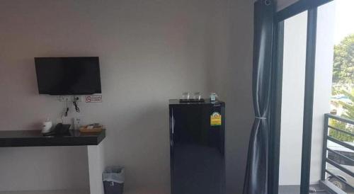 ein schwarzer Kühlschrank in einem Zimmer mit einem TV in der Unterkunft The Bed Hotel Phitsanulok in Sathani Phitsanulok