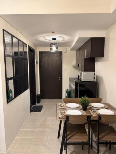 une cuisine avec une table et des chaises dans une pièce dans l'établissement NFr, à Manille