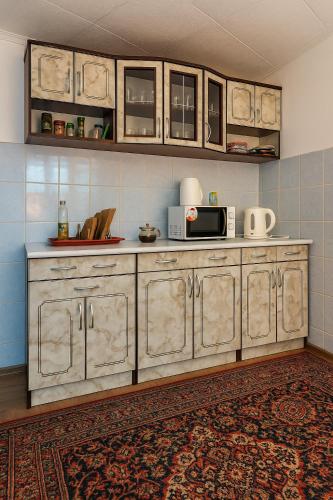 a kitchen with a microwave on top of a counter at Helena guest house in Cholpon-Ata