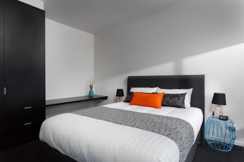 1 dormitorio con 1 cama grande con almohadas de color naranja y negro en Bimbadeen Phillip Island Farm Retreats en Ventnor