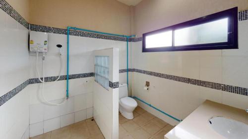 a bathroom with a shower and a toilet and a window at Sawasdee River Kwai Lodge in Ban Hua Hin