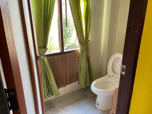 a bathroom with a toilet and a window at Aroma Pai Spa Hotel in Pai