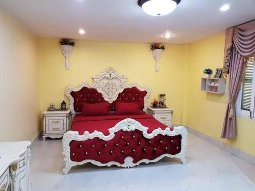 a red bed with red pillows in a bedroom at Chateau de Sangkhlaburi in Sangkhla Buri