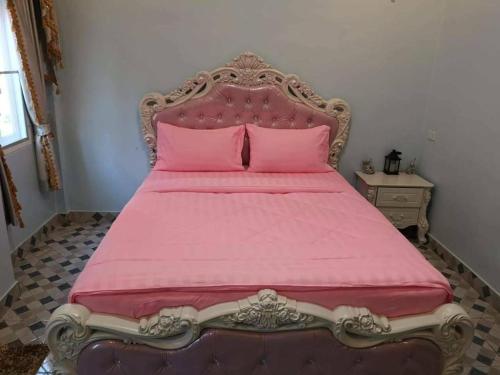 a large pink bed with a pink bedspread at Chateau de Sangkhlaburi in Sangkhla Buri