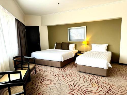 a hotel room with two beds in a room at Impiana Hotel Ipoh in Ipoh
