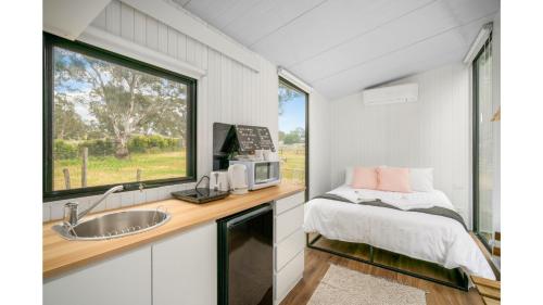 a kitchen with a bed and a sink and a window at Skye High Cabin by Tiny Away in Lyndhurst South