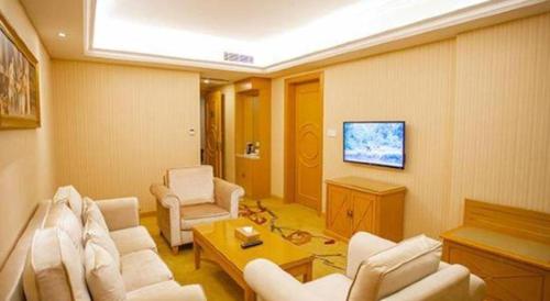 a living room with a couch and chairs and a tv at Vienna Hotel Shenzhen Bao'an Airport Taoyuanju Pingluanshan Metro Station in Shenzhen