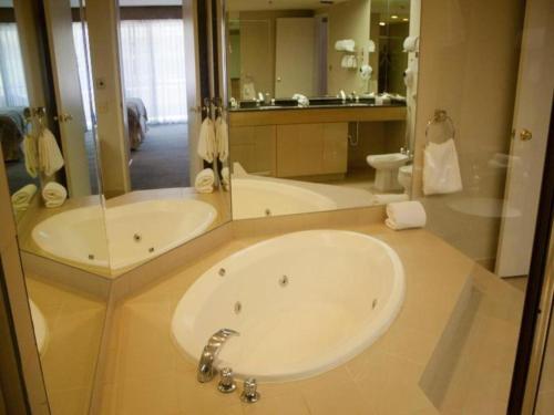 une salle de bain avec deux lavabos et un grand miroir dans l'établissement Marquis Villas Resort, à Palm Springs