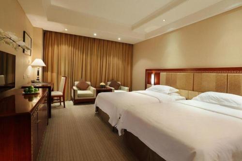 a hotel room with a large bed and a desk at Capital Hotel in Beijing