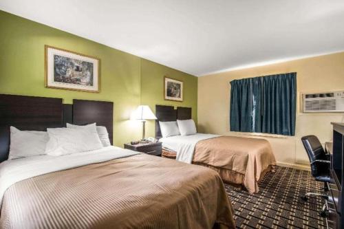 a hotel room with two beds and a window at Rodeway Inn in Rutland