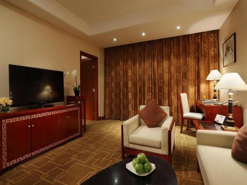 a living room with a couch and a tv at Capital Hotel in Beijing