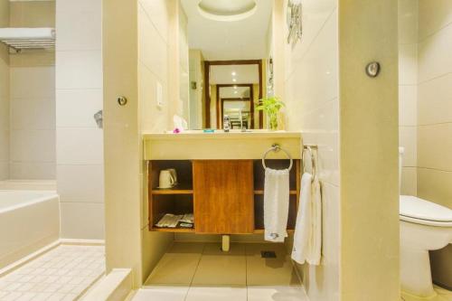 a bathroom with a sink and a toilet at Huachen Kenzo Hotel Hangzhou in Hangzhou