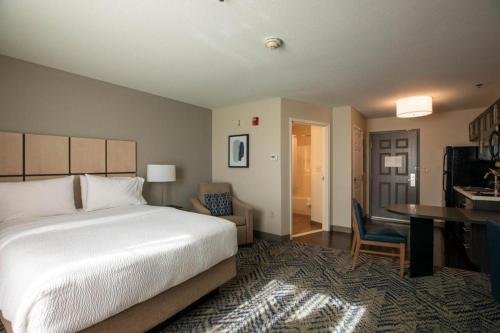 ein Hotelzimmer mit einem Bett und einem Schreibtisch und einem Schreibtisch in der Unterkunft Candlewood Suites Saint Joseph By IHG in Saint Joseph