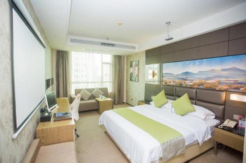 a bedroom with a large bed and a large painting on the wall at GreenTree Alliance Shenzhen Shekou Sea World Hotel in Shenzhen