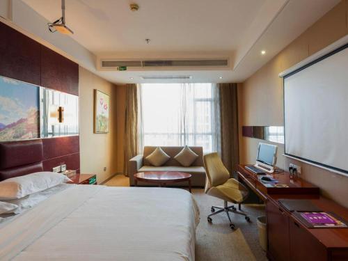 a hotel room with a bed and a desk with a computer at GreenTree Alliance Shenzhen Shekou Sea World Hotel in Shenzhen