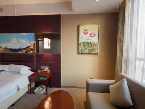 a hotel room with a bed and a couch at GreenTree Alliance Shenzhen Shekou Sea World Hotel in Shenzhen