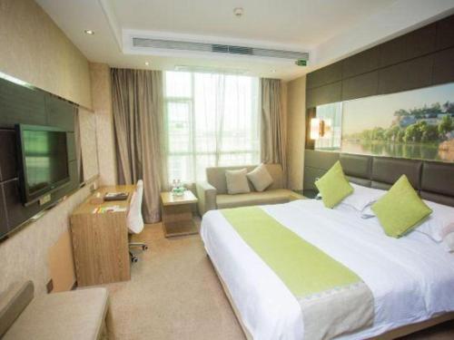 a hotel room with a large bed and a couch at GreenTree Alliance Shenzhen Shekou Sea World Hotel in Shenzhen