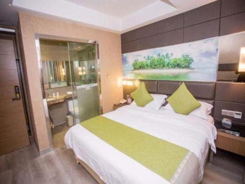 a bedroom with a large bed with a painting on the wall at GreenTree Alliance Shenzhen Shekou Sea World Hotel in Shenzhen