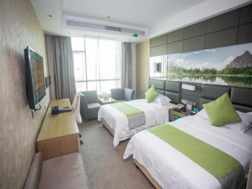 a hotel room with two beds and a television at GreenTree Alliance Shenzhen Shekou Sea World Hotel in Shenzhen