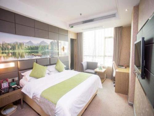 a bedroom with a large bed and a flat screen tv at GreenTree Alliance Shenzhen Shekou Sea World Hotel in Shenzhen