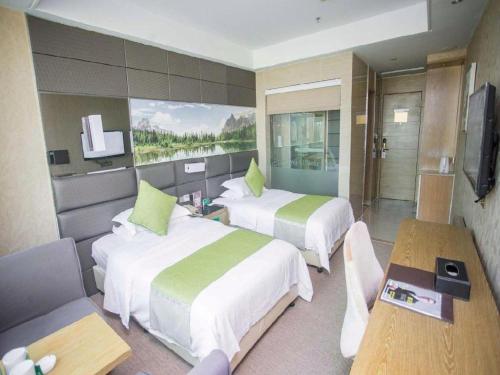 a hotel room with two beds and a television at GreenTree Alliance Shenzhen Shekou Sea World Hotel in Shenzhen
