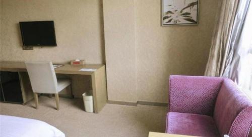 a hotel room with a desk and a purple chair at GreenTree Alliance Shenzhen Shekou Sea World Hotel in Shenzhen