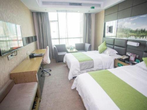 a hotel room with two beds and a desk at GreenTree Alliance Shenzhen Shekou Sea World Hotel in Shenzhen