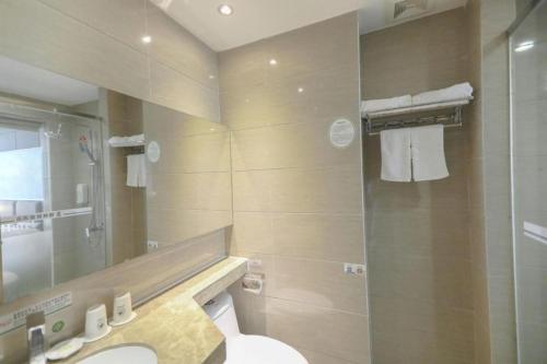 a bathroom with a shower and a toilet and a sink at GreenTree Alliance Shenzhen Shekou Sea World Hotel in Shenzhen