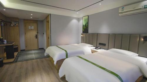 Ένα ή περισσότερα κρεβάτια σε δωμάτιο στο GreenTree Inn LiaoCheng LinQing HaiShan Building Express Hotel