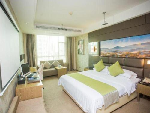a hotel room with a large bed and a couch at GreenTree Alliance Shenzhen Shekou Sea World Hotel in Shenzhen