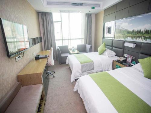 a hotel room with two beds and a television at GreenTree Alliance Shenzhen Shekou Sea World Hotel in Shenzhen