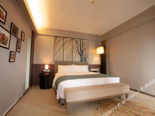 a bedroom with a large bed and a window at Chambery Hotel in Zhuhai
