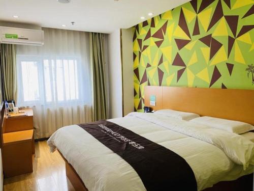 a bedroom with a large bed with a colorful wall at Vatica Beijing Tongzhou Liyuan Universal Studios in Beijing