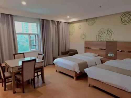 a hotel room with two beds and a table and chairs at GreenTree Inn Fuzhou Eastern Capital Express Hotel in Shiliting