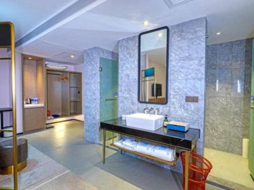 a bathroom with a sink and a mirror at Nuohuating Hotel in Zhaoqing