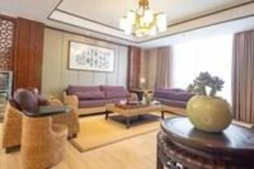 a living room with a purple couch and a table at Excemon Beach Hotel Beihai in Beihai