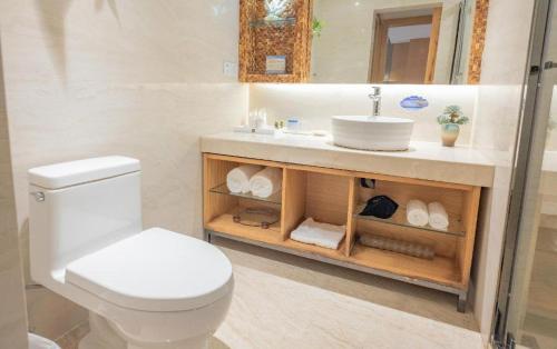 a bathroom with a white toilet and a sink at Excemon Beach Hotel Beihai in Beihai
