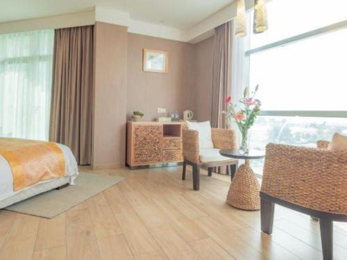 a bedroom with a bed and a table and chairs at Excemon Beach Hotel Beihai in Beihai