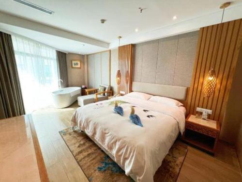 a bedroom with a large bed with two birds on it at Excemon Beach Hotel Beihai in Beihai