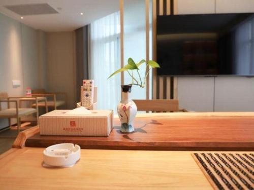 a vase sitting on top of a wooden table at Excemon Beach Hotel Beihai in Beihai