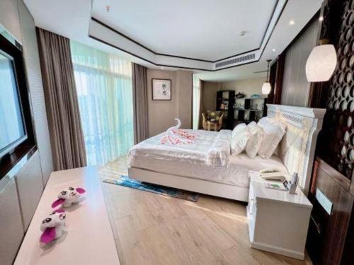 a bedroom with a bed and a desk with stuffed animals at Excemon Beach Hotel Beihai in Beihai