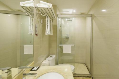 a bathroom with a toilet and a glass shower at Jingtu hotel zhanjiang dingsheng plaza store in Zhanjiang