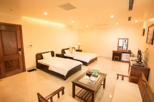a hotel room with two beds and a table at Lakeside Hotel Nam Dinh in Như Thức