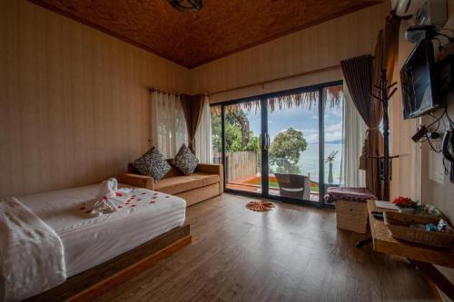 a bedroom with a bed and a large window at DECHO BEACH RESORT in Ko Lipe