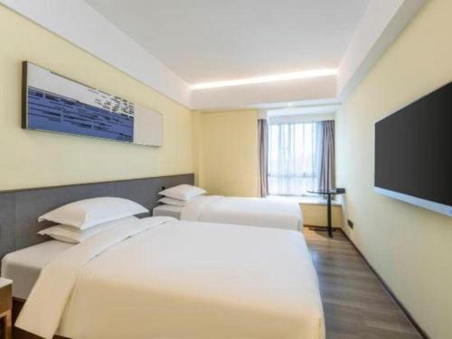 a hotel room with two beds and a flat screen tv at AURAYA BY SUNING NANJING XUZHUANG in Nanjing