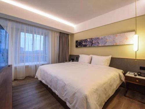 a hotel room with a large bed and a television at AURAYA BY SUNING NANJING XUZHUANG in Nanjing