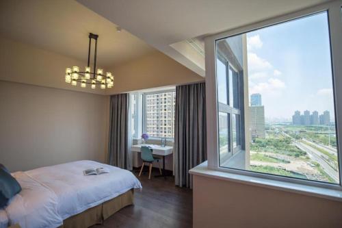 a hotel room with a bed and a large window at Moqi Hotel Wuhan in Wuhan