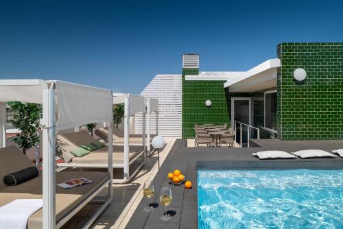 een achtertuin met een zwembad en een huis bij Ópera Apartments Alameda in Sevilla