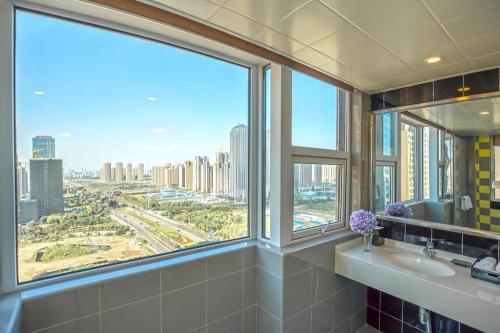 a bathroom with a view of a city from a window at Moqi Hotel Wuhan in Wuhan